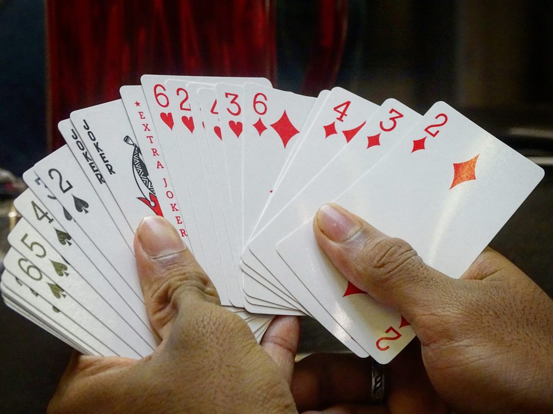 Person holding cards including 3 jokers